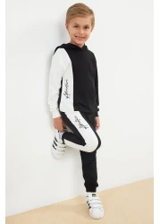 TRENDYOLKIDS طقم سويت شيرت وبدلة رياضية بغطاء للرأس من القطن باللون الأسود للأولاد - TKDAW25AU00058