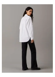 Calvin Klein قميص جينز قياسي بياقة مطرزة باللون الأبيض للنساء، قميص WOVEN LABEL المريح